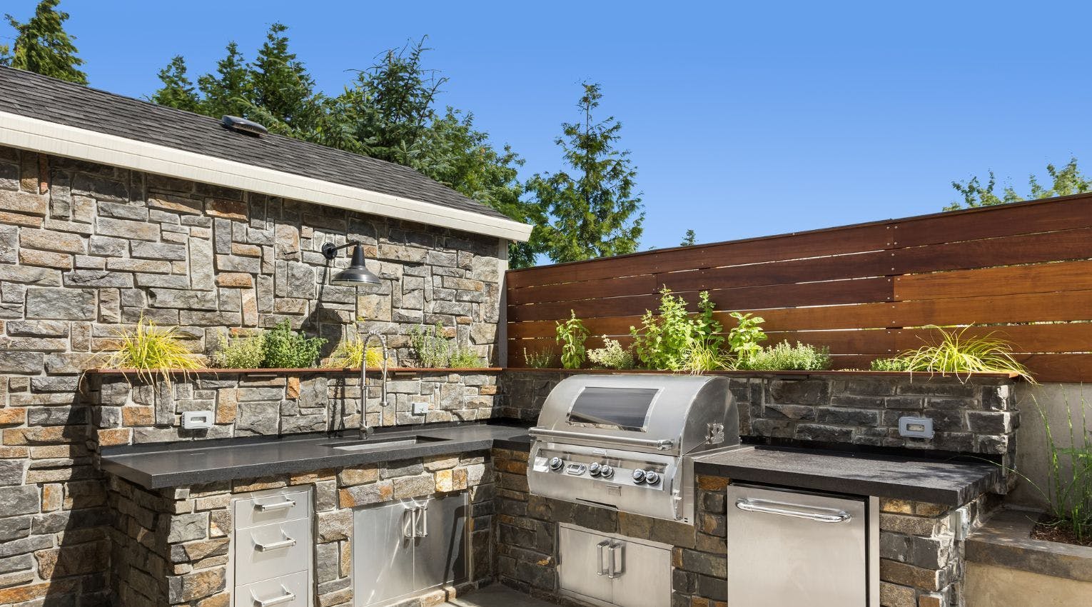 outdoor kitchen with stone vineer and grill