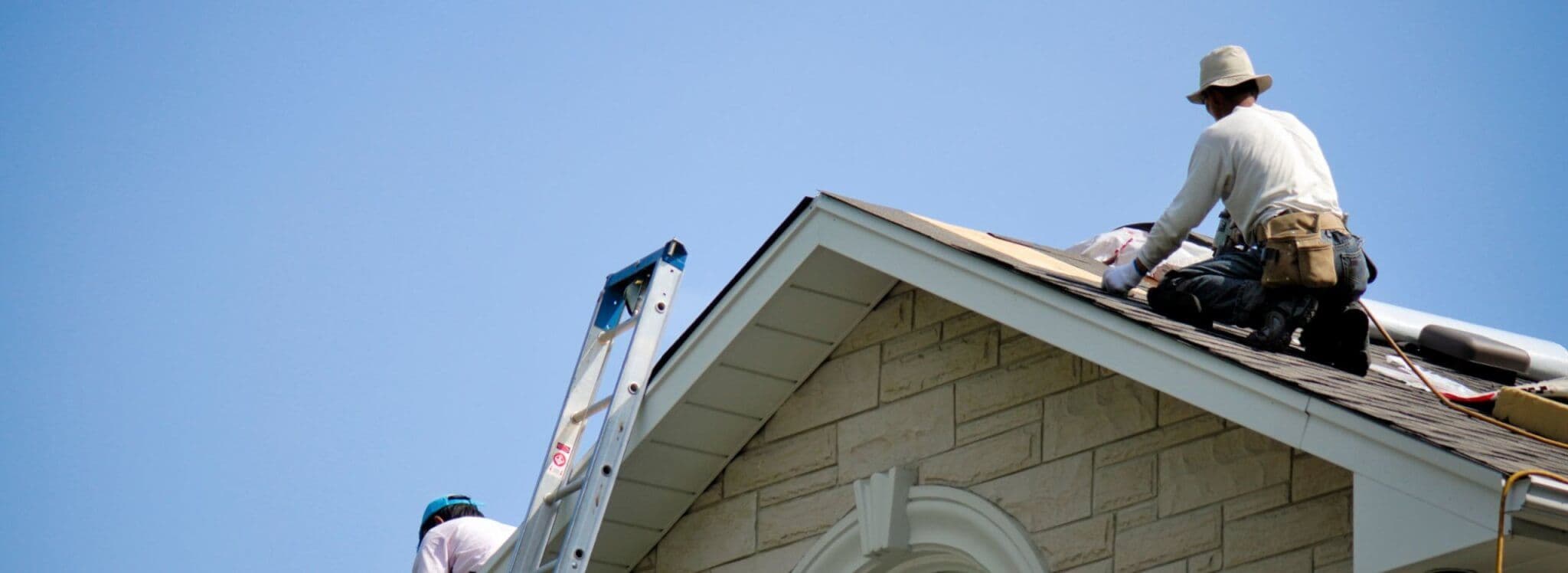 Man repairing shingles on roof