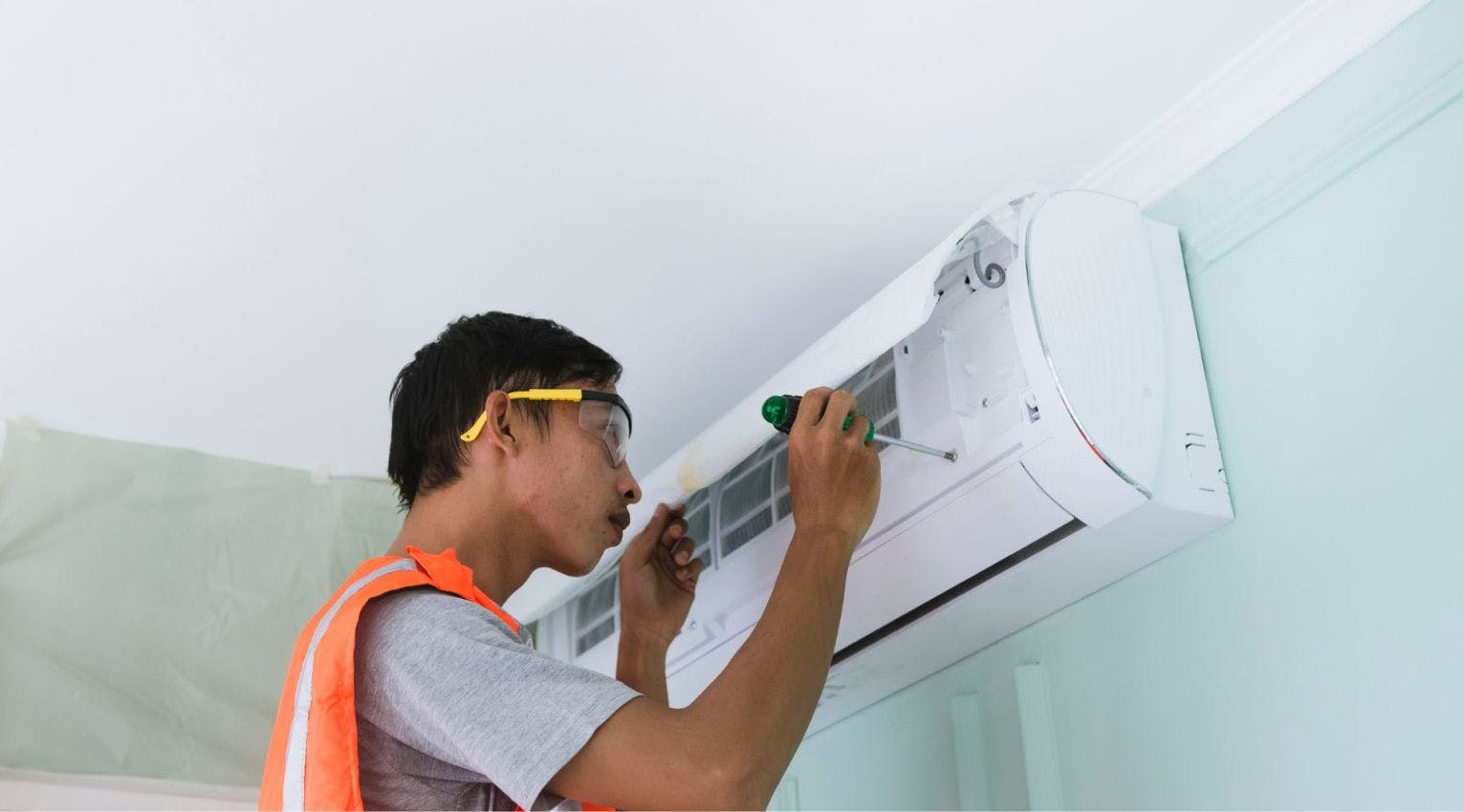 Person repairing air conditioning unit
