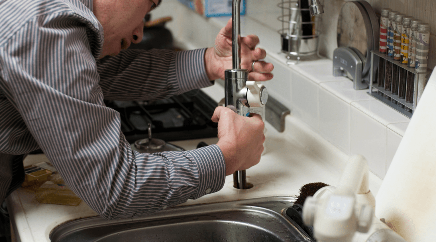 Plumber repairing leaky sink